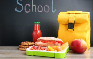 Appetizing Food in Lunch Box and Bag on Table Near Chalkboard With Word School