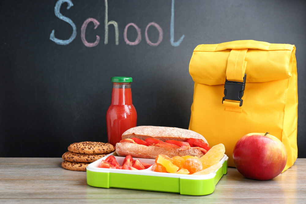 Appetizing Food in Lunch Box and Bag on Table Near Chalkboard With Word School